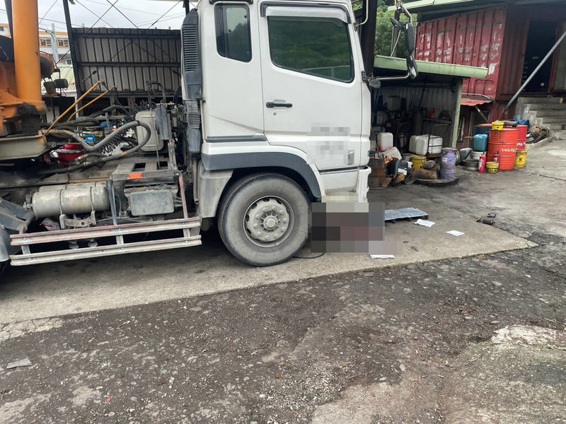 基隆市光華路一間修車廠老闆陳姓男子12日下午在廠內維修砂石車時，疑千斤頂承受不住砂石車重量垮下，砂石車壓到陳男，陳男送醫急救仍不治。（讀者提供）中央社記者王朝鈺傳真  113年12月12日