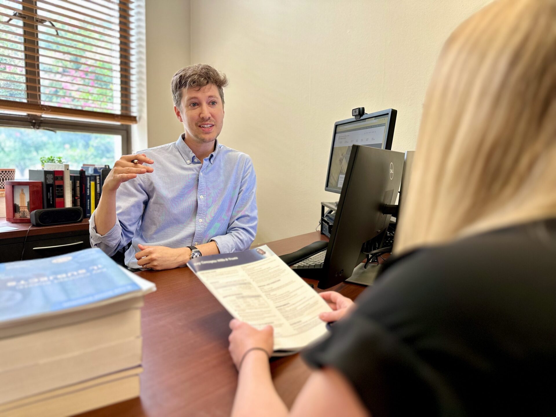 Christopher Sokol, sitting at his desk, advising a student