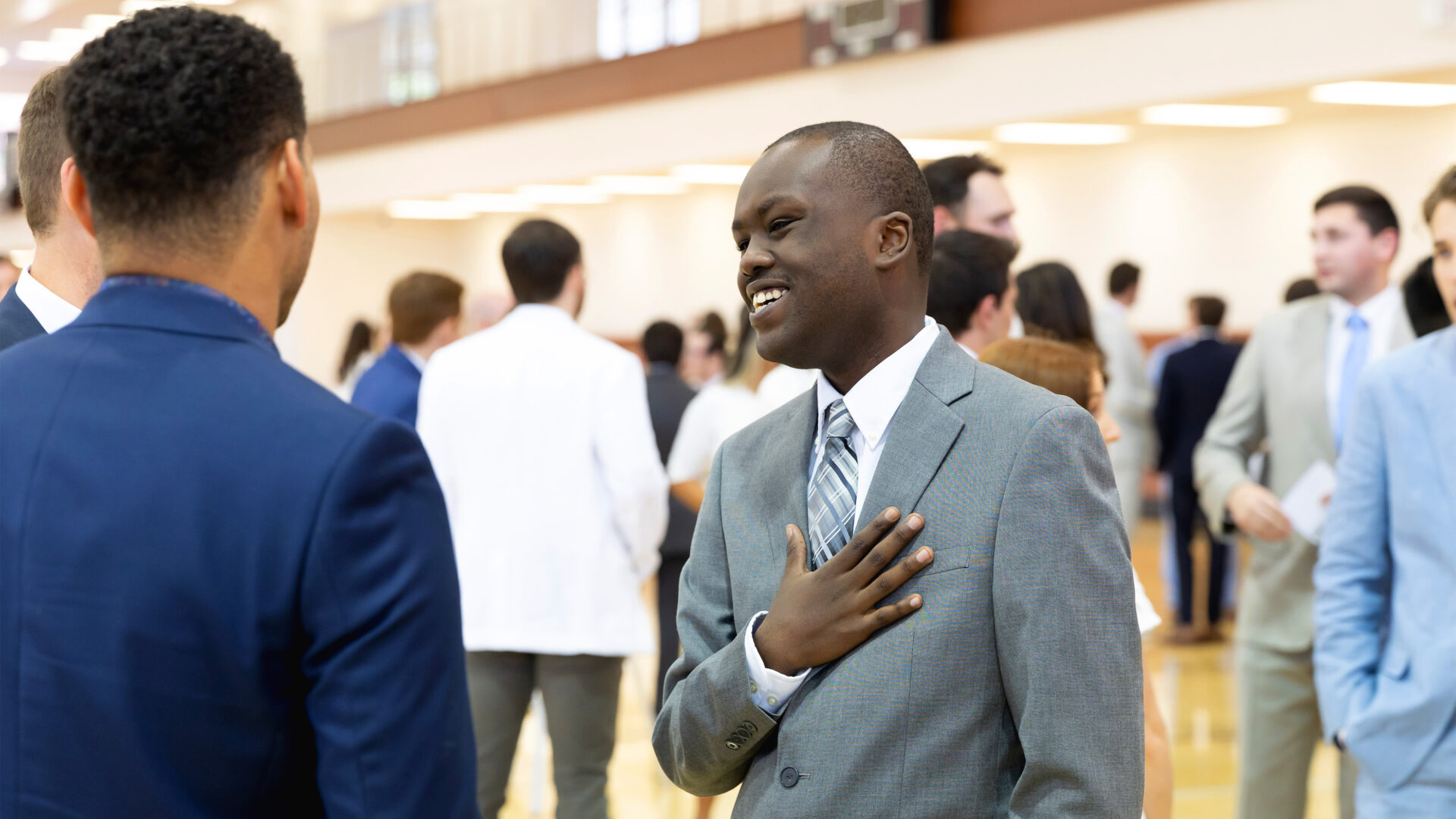 man wearing suit with hand on chest