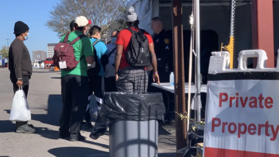 Asylum seekers stand outside the San Antonio Migrant Resource Center in Texas