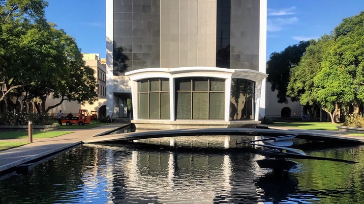 tall building with wading pool fountain and bridge