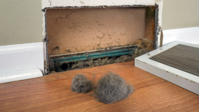 Dust bunny on the ground in front of a home air vent