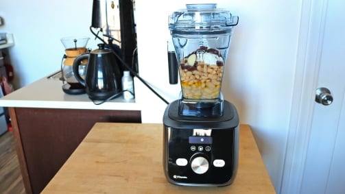 A Vitamix blender with beans inside the container.