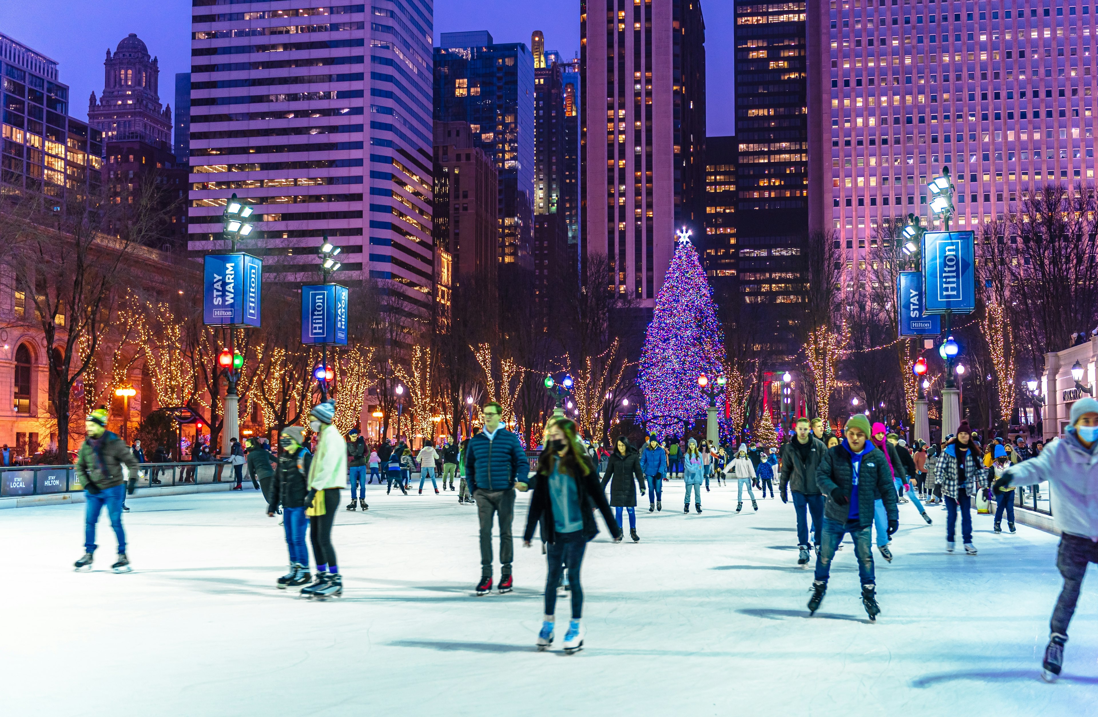 People are enjoying ice skating during beautiful winter night in Millennium Park Ice Rink