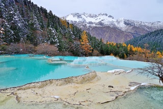 Situated in northwest Sichuan's Minshan mountain range the Huanglong Scenic Area offers striking views of snowy mountain...