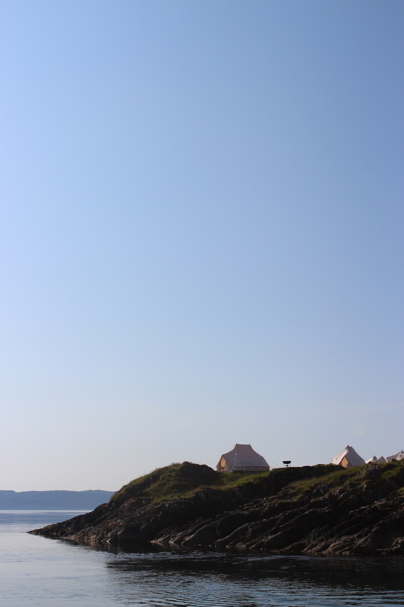 Image may contain Nature Outdoors Sky Rock Promontory Water Land Sea Tent Scenery Horizon Shoreline and Coast