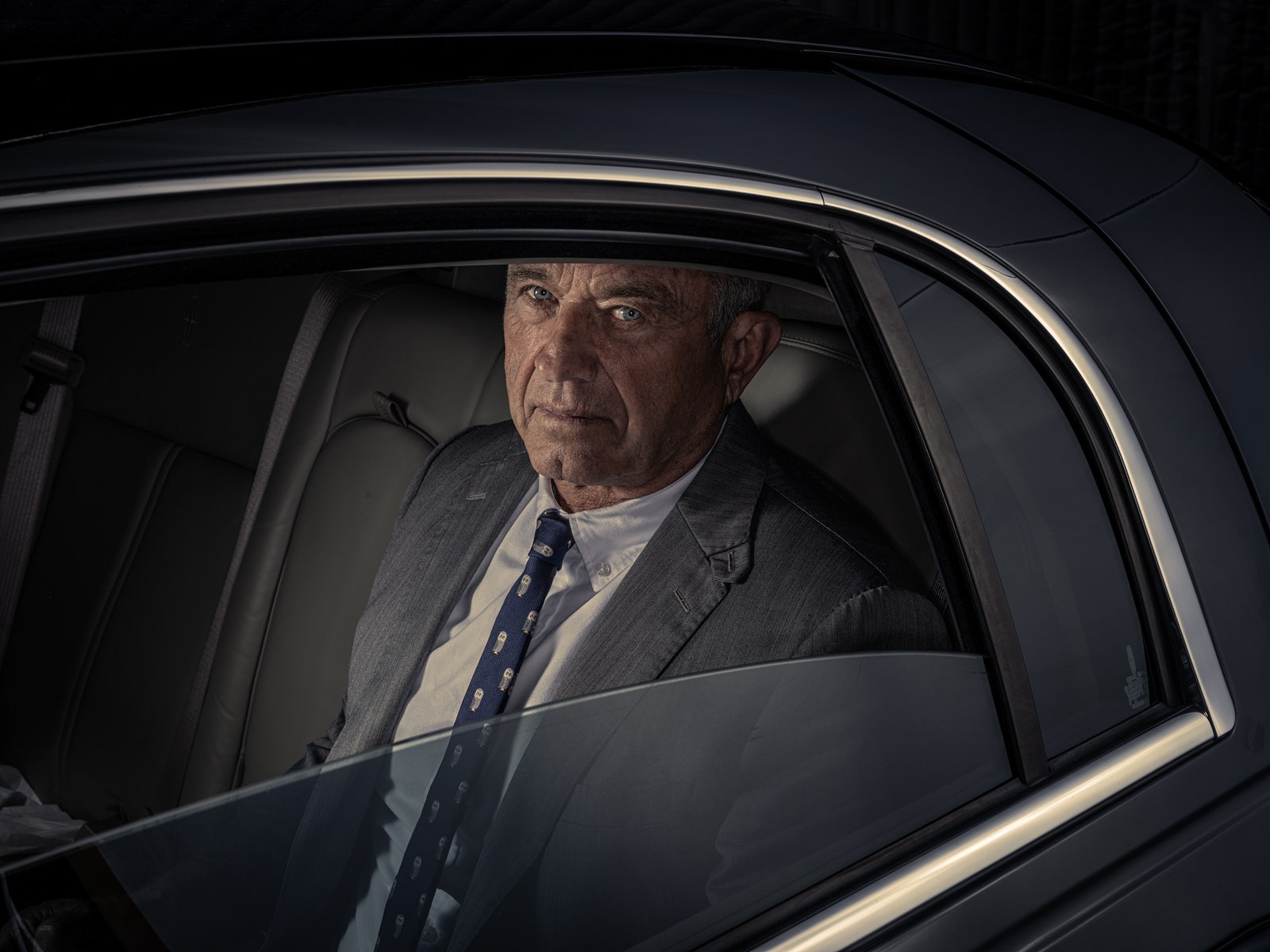 Robert F. Kennedy Jr. photographed sitting in the backseat of a car by Dan Winters for The New Yorker.