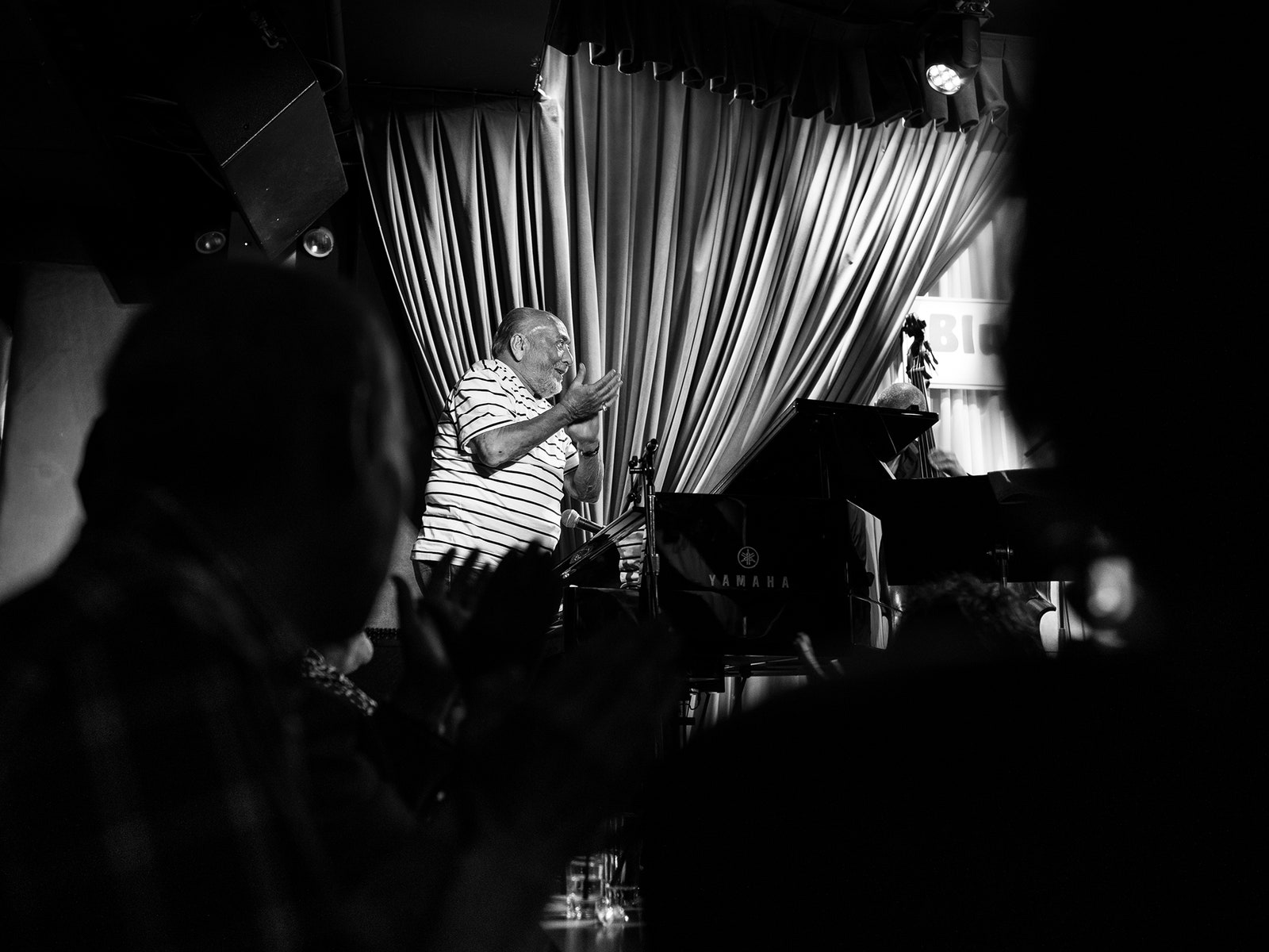 A blackandwhite photo of Eddie Palmieri clapping onstage.