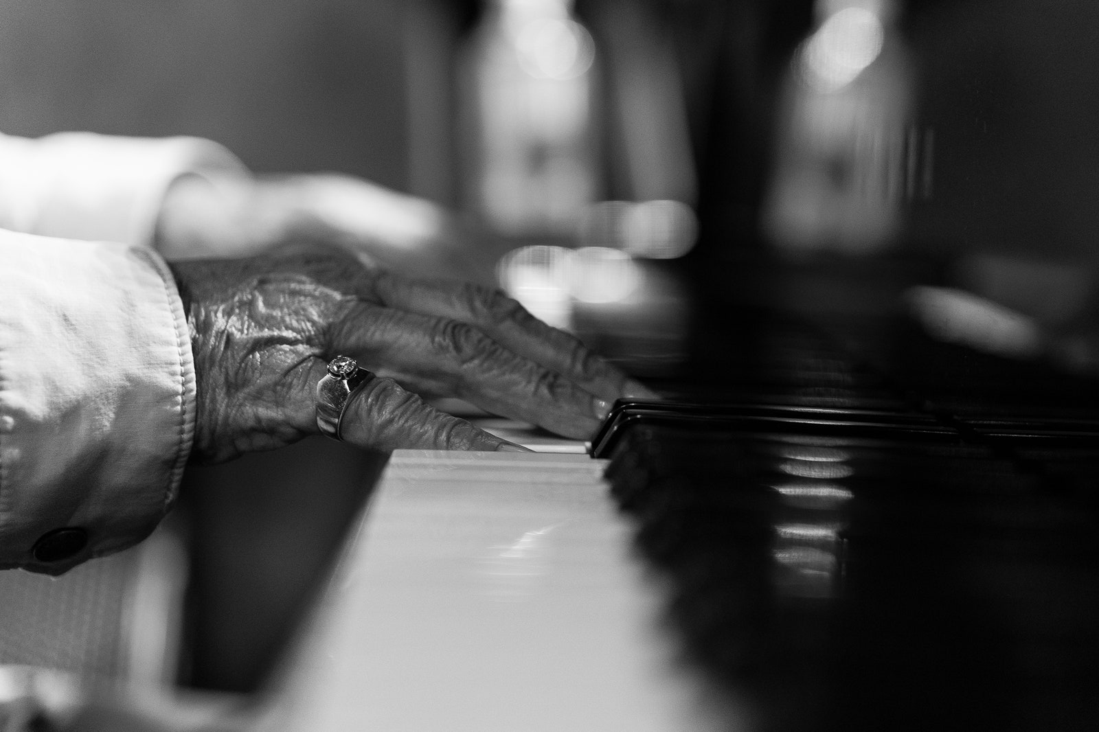 Hands playing a piano.