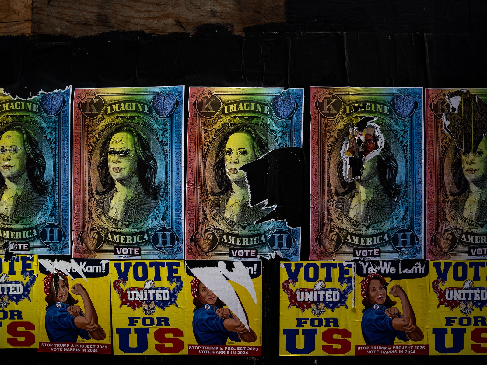 Torn posters for Kamala Harris on a dark wall.