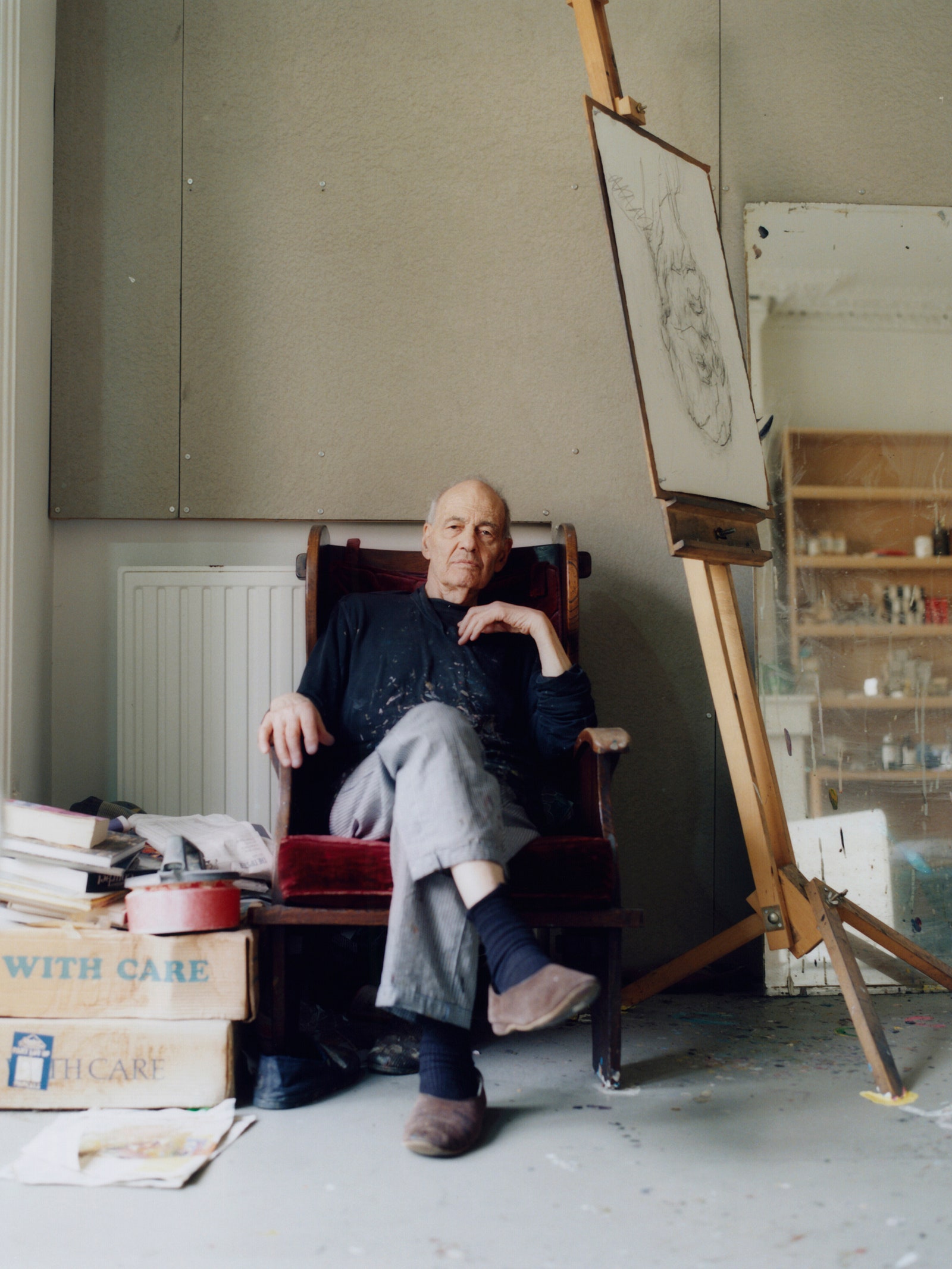 The artist Frank Auerbach sitting in a chair.