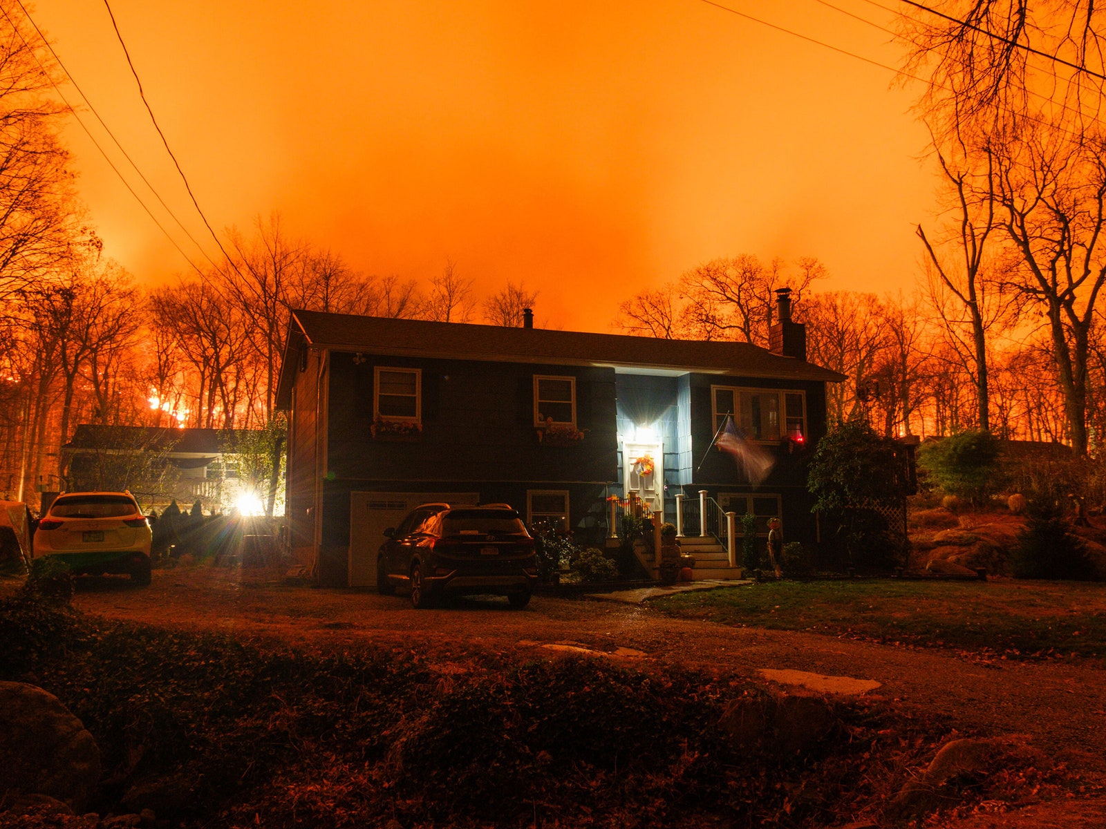 A home in Jennings Creek with orange clouds of smoke from the fire in the background.