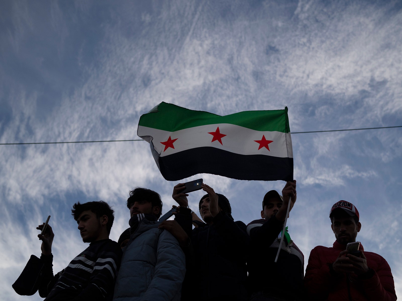 A photo of people carrying a Syrian opposition flag.