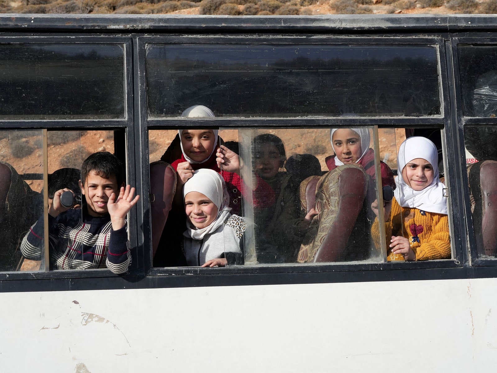 Children look out of a bus