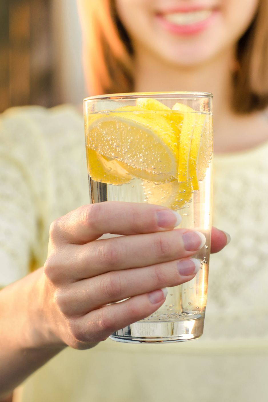 Diet. Healthy eating. Woman hand holding lemonade drink on the background blurred nature outdoor. Fresh detox vegetable...