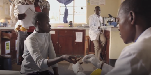 A doctor swabs a young boys finger.