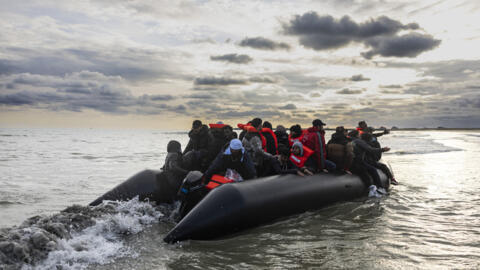 Migrants board a smuggler's boat on the beach of Gravelines in northern France on April 26, 2024.