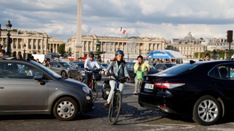 Cyclists squeeze their way through traffic on Place de la Concorde in central Paris.