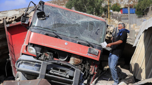 Un homme retire des documents d'un camion endommagé dans une zone industrielle détruite par une frappe aérienne israélienne, à Wadi al-Kfour, province de Nabatieh, sud du Liban, le samedi 17 août 2024.