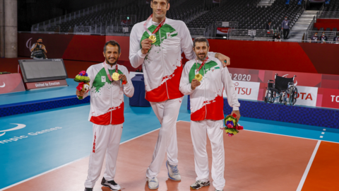 Morteza Mehrzad pictured standing between Iranian teammates after winning gold at the Tokyo 2020