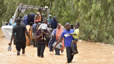 This photograph taken on 20 August, 2024 shows police boats carrying people following heavy rains that damaged main roads connecting the Nigerien capital Niamey to western Nigerien provinces.