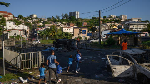 A burnt car and debris in Fort-de-France, Martinique, following protests over the cost of living, 23 September 2024.