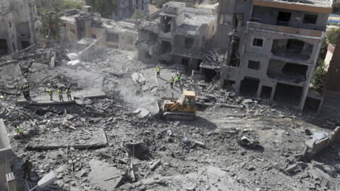 Des secouristes utilisent un bulldozer pour enlever les décombres des bâtiments détruits touchés par les frappes aériennes israéliennes dans le village de Cana, au sud du Liban, le 16 octobre 2024.