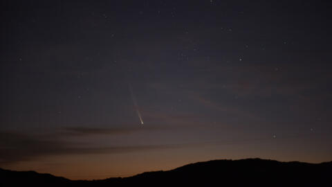 O cometa C2023 A3 Tsuchinshan-Atlas visto sobre as colinas próximas ao vilarejo de Águas Blancas, departamento de Lavalleja, Uruguai, na madrugada de 28 de setembro de 2024. (Foto de Mariana SUAREZ / AFP)