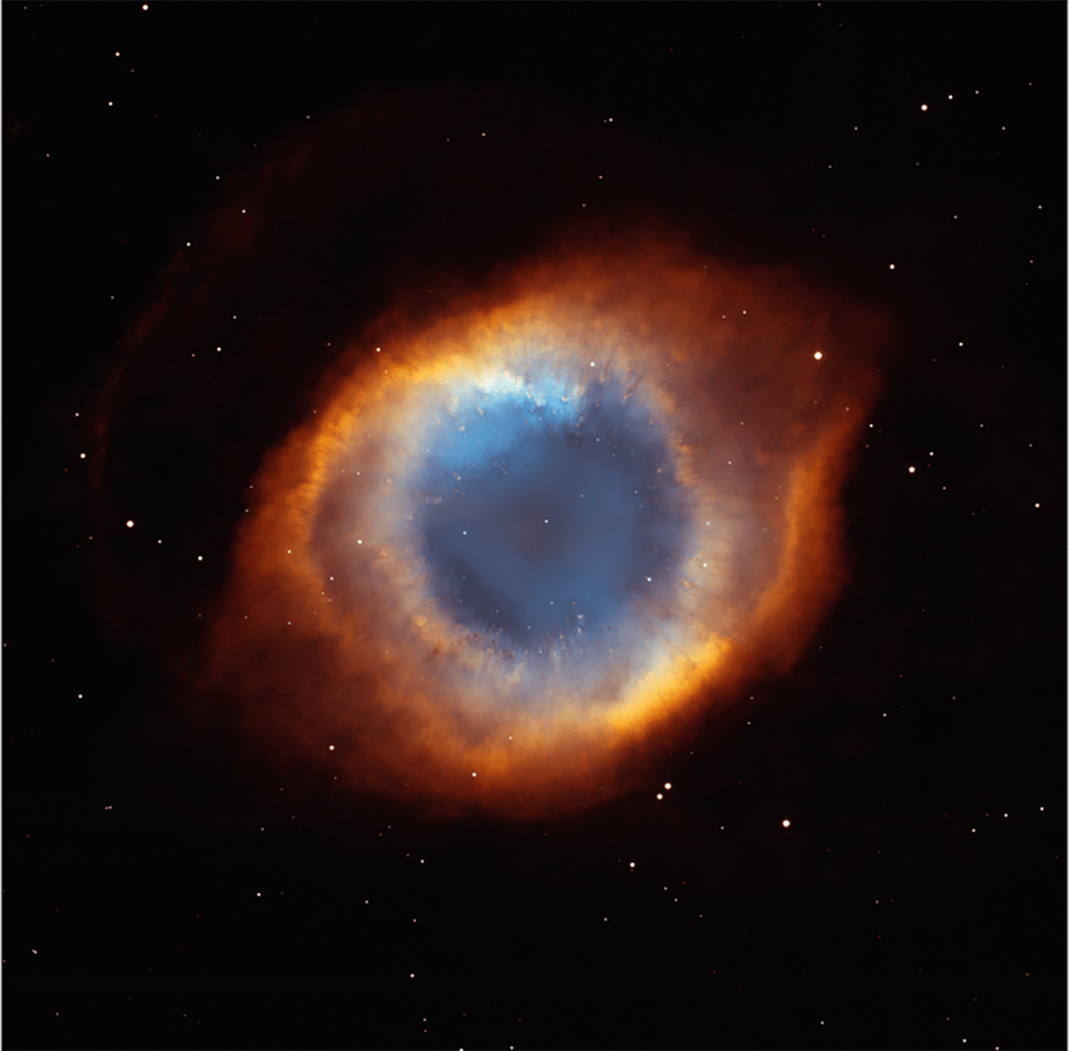 This nebula resembles an eye, with the "pupil" immediately around the star appearing a light blue, the "iris" fading into a mixture of blue, orange, and red with a yellow-orange ring around it, and the sclera appearing bright red-orange.