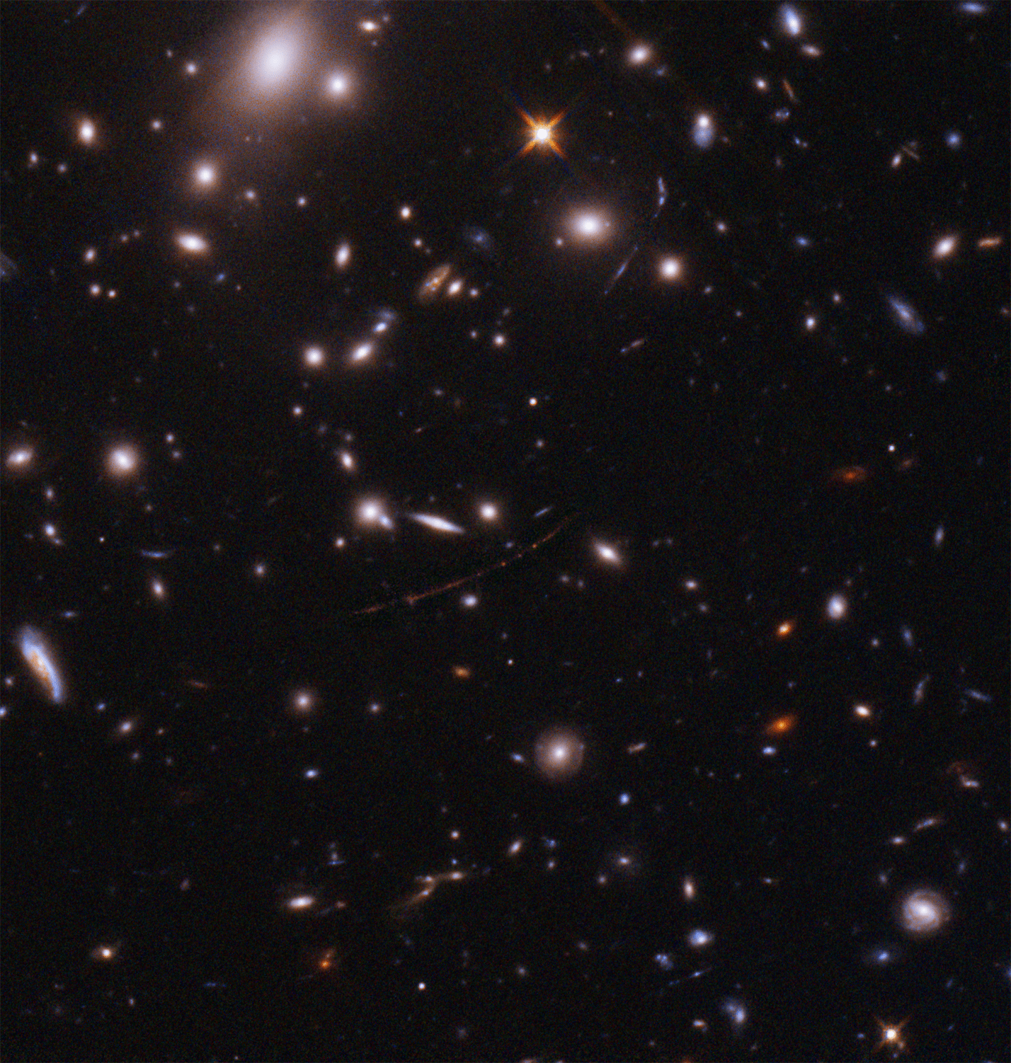 Galaxies dot a black sky. a faint red arc holds three dots. the two outer dots are a lensed star cluster, the center dot is the farthest known star, dubbed Earendel.