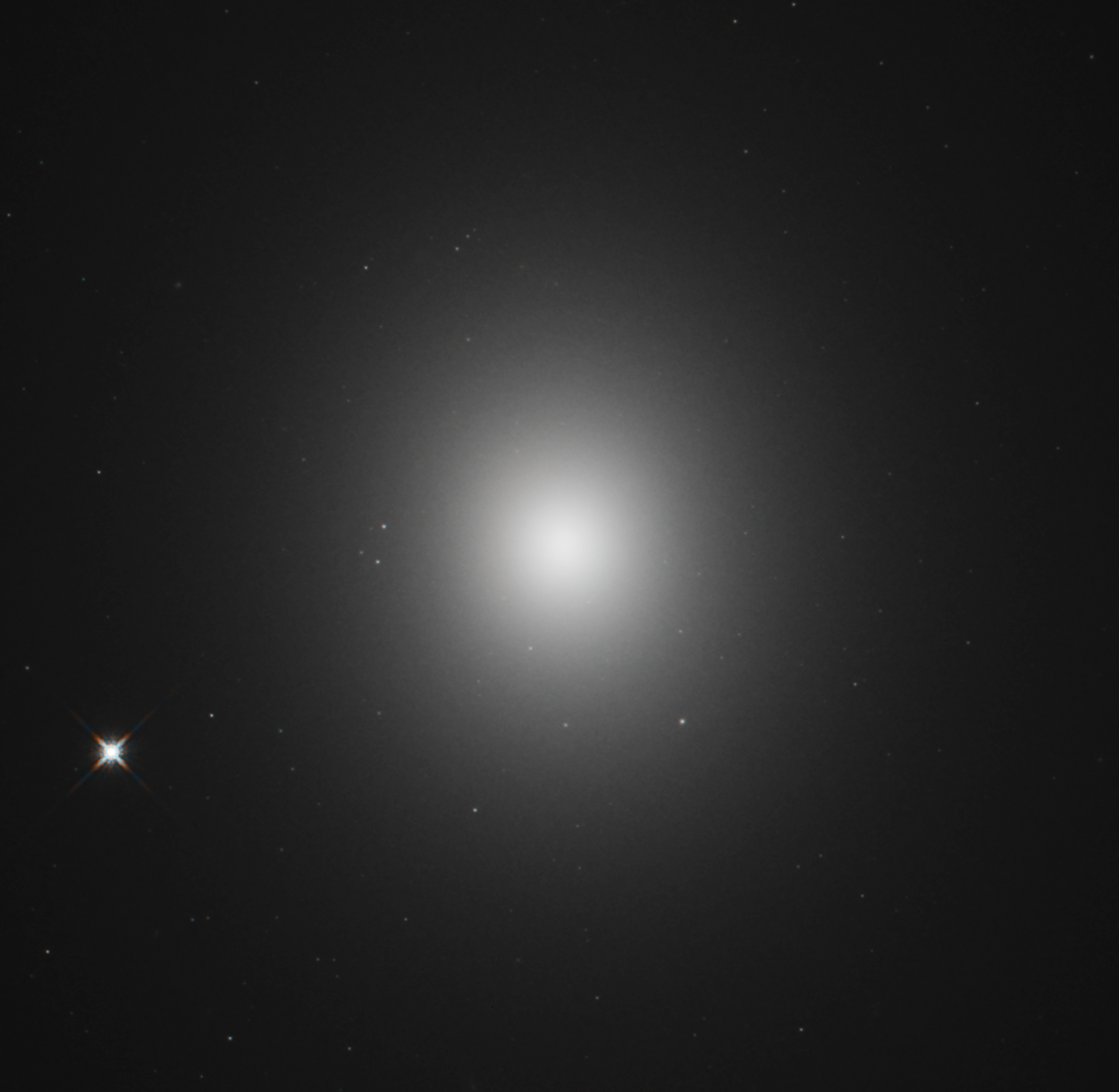 A blurred/soft elliptical galaxy of stars at the center.