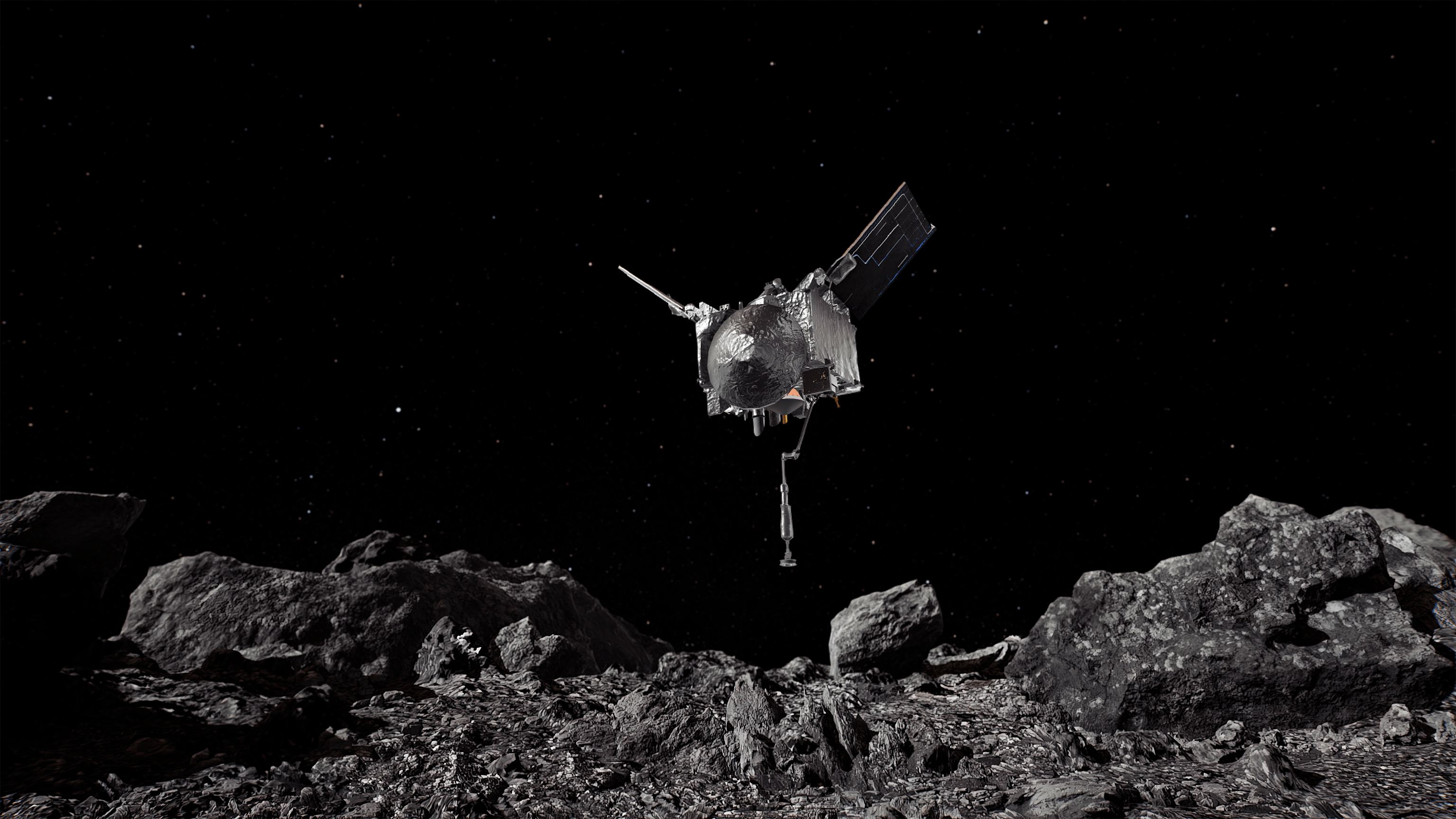 An artistic visualization of the OSIRIS-REx spacecraft hovering above the surface of Asteroid Bennu. The spacecraft is silver, shiny with two wings on the top and a long extension from the bottom.