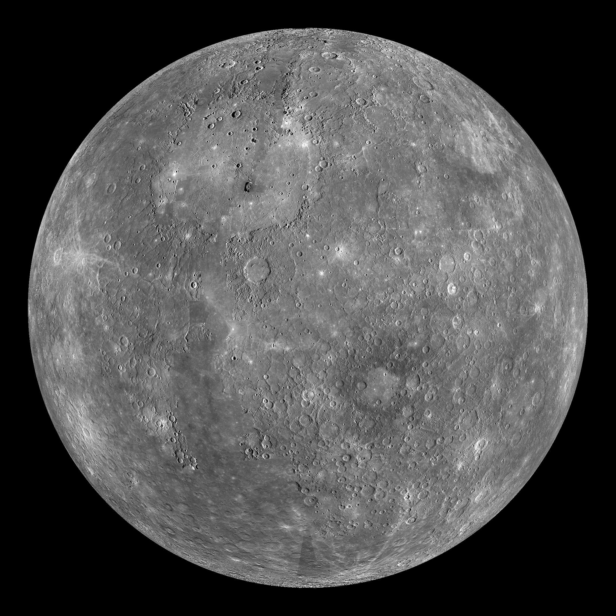 A full globe view of gray-colored planet Mercury as seen from a spacecraft. Craters and white patches also are visible.