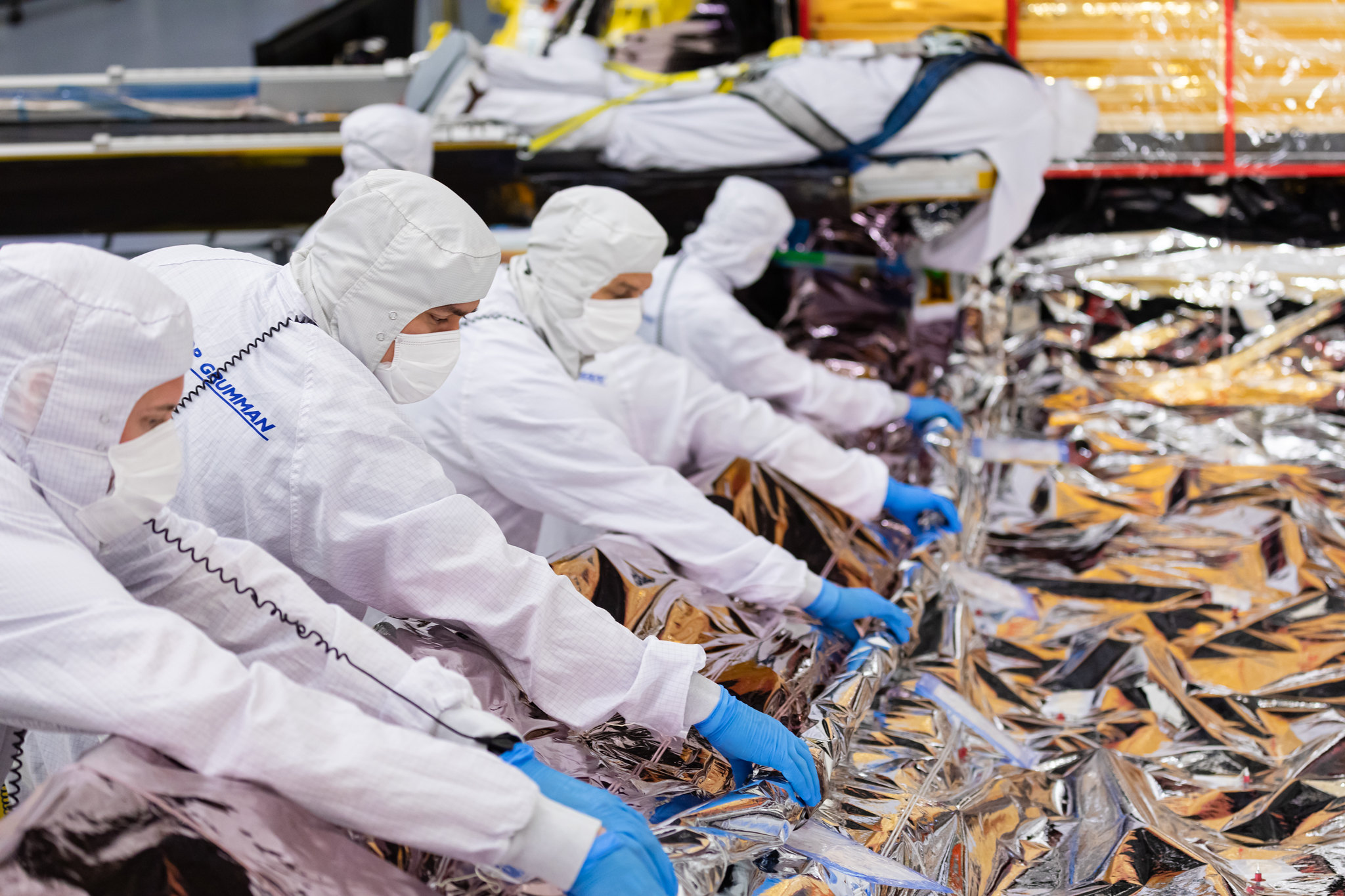 This archival image was taken in February 2021 and shows the James Webb Space Telescope's sunshield being folded and packed by engineers and technicians at Northrop Grumman.