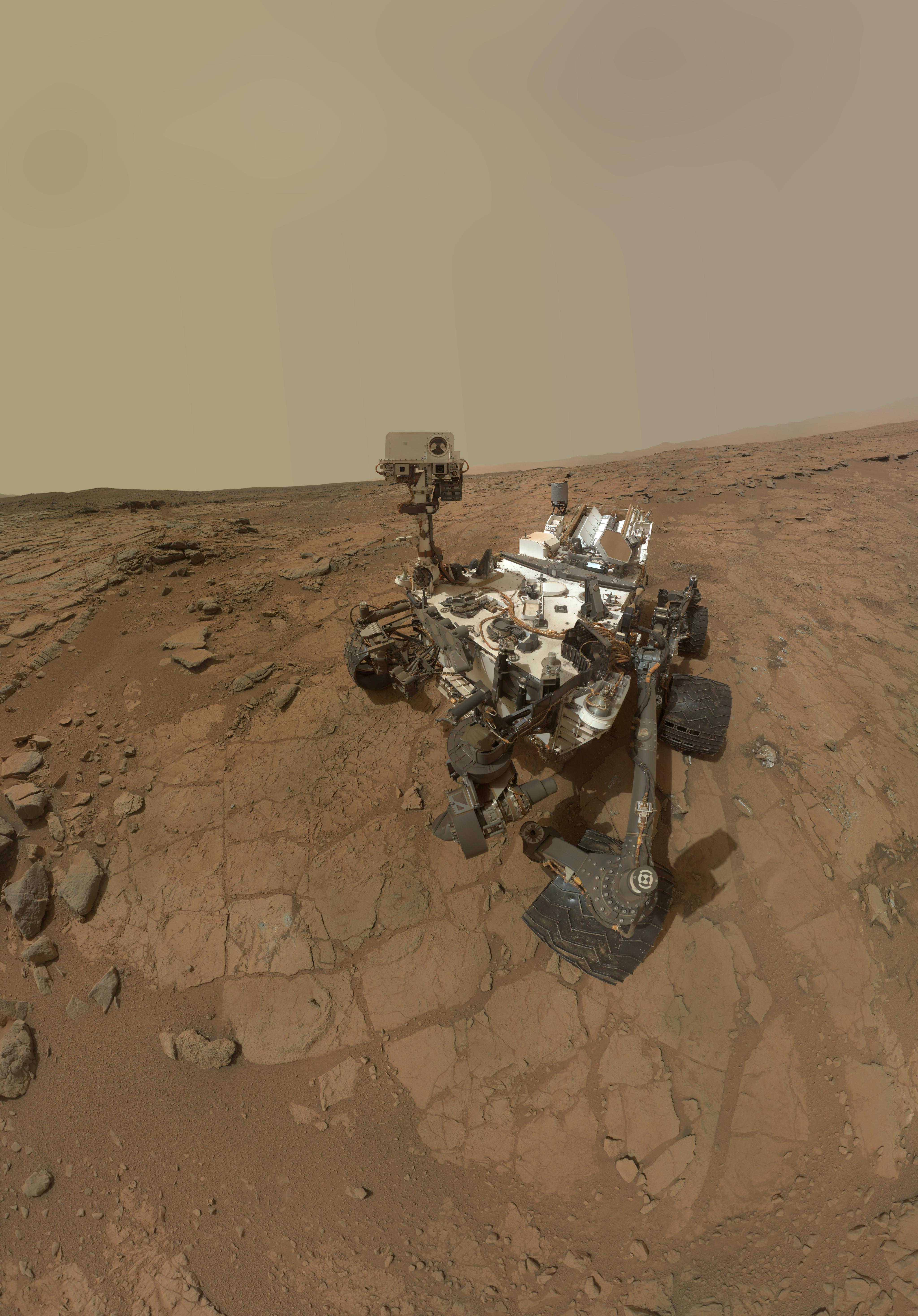 A Mars rover is parked among the tire tracks it made on Mars in this composite image.