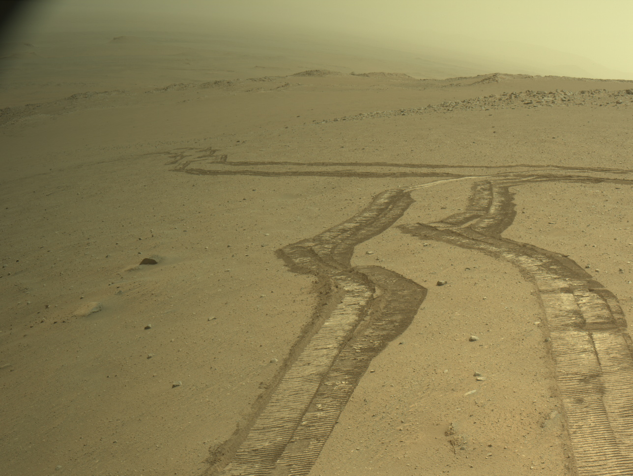 Image from Perseverance’s Right Navigation Camera, looking back towards rover tracks from past drives, into Jezero crater. The camera is located high on the rover mast, and here the rover is looking back in the direction of the Jezero crater floor.