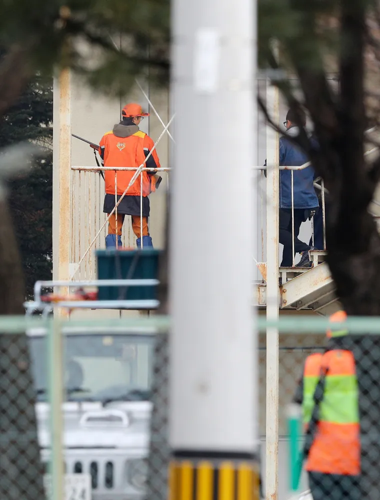 帯広市内の小学校に出没したクマの対応に追われる猟友会のハンターら=2019年12月