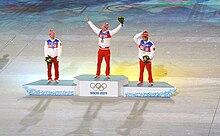 Vue de loin du podium des 50 kilomètres des Jeux de Sotchi, le vainqueur levant les bras en l'air.