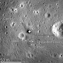 Le site d'atterrissage d'Apollo 11 photographié par la sonde LRO en 2012 : on peut distinguer le module lunaire, des traces de pas et certains équipements installés par l'équipage.