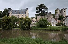 Photographie en couleurs d'une rivière calme au pied d'un château.