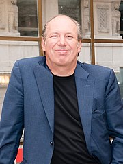 Photographie de face d'un homme blanc souriant, le crâne dégarni.