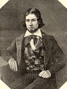 Engraving of a young man with hair parted in the middle, wearing a plaid vest and suit coat. He is looking at the viewer.