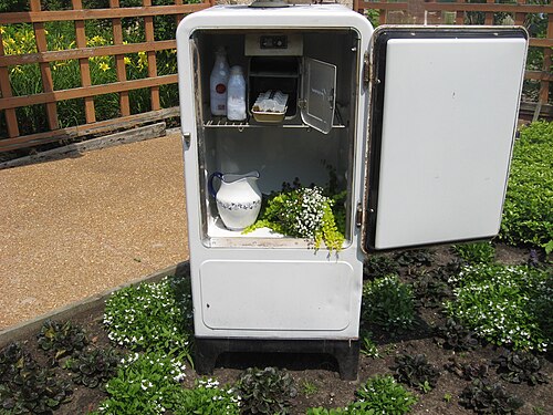 old refrigerator being used as décor for an outdoor garden