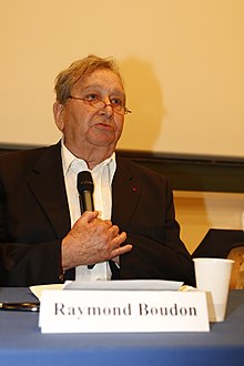 A older male sociologist sitting at a table as a panelist.