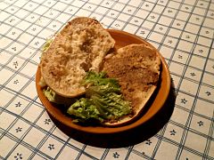 Photographie en couleurs de tranches de pain tartinées de rillettes de Tours dans une assiette.