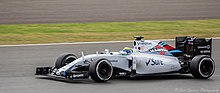 Photographie d'une monoplace de Formule 1 blanche, vue de trois-quarts, dans son ensemble, sur une piste sèche.