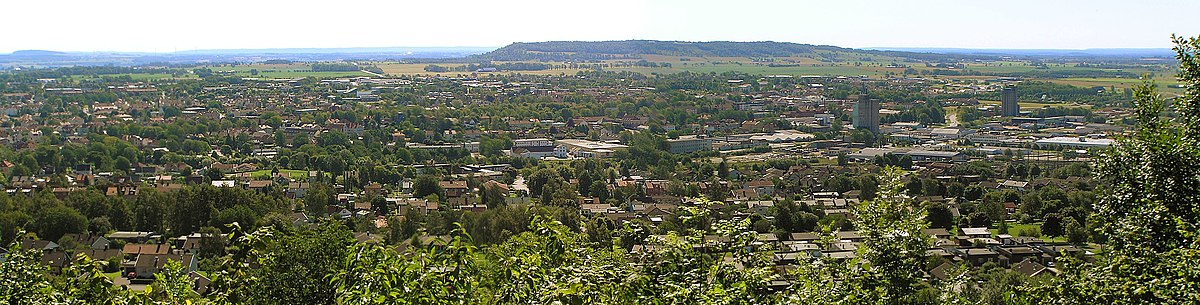 Falköping från Mösseberg. I bakgrunden i öster Ålleberg. Stadens centrum och Sankt Olofs kyrka bakom silon till höger i bild. Järnvägsstationen utanför bildens vänstra kant.