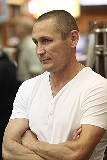 Colour photo of Anatoly Alexandrov aged 44. he is wearing a white t-shirt and crossing his arms