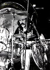 A black and white photograph of John Bonham playing drums