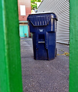 Recycle bin behind a green gate